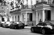 A residential street with cars parked.